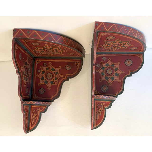 Charming pair of Moroccan wood corner shelves. The large scale shelves are painted with mandala designs in shades of red,...