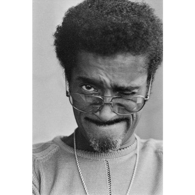 Sammy Davis Jr In London American singer, dancer, actor and comedian Sammy Davis Jr wearing spectacles while squinting one...