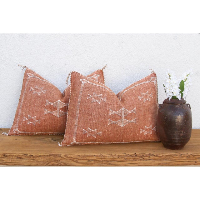 Sold as a matching pair, these handcrafted Moroccan cactus silk lumbar pillows feature a stacked bowtie-diamond medallion...