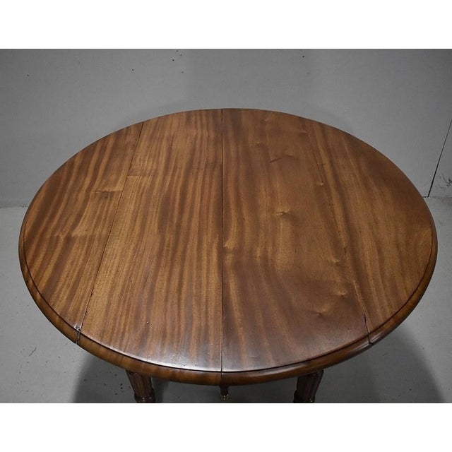 Small Louis-Philippe style round table in blond mahogany with a diameter of 115cm, with flaps, the top of which is made up...