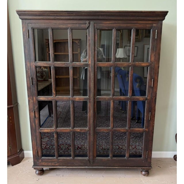 This Crate and Barrel library bookcase features a dark, richly distressed wood finish, substantial crown molding, and two...