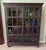This Crate and Barrel library bookcase features a dark, richly distressed wood finish, substantial crown molding, and two...