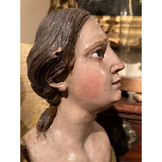 This masterfully carved and lacquered Italian wooden female bust exemplifies the exquisite artistry of 18th-century...