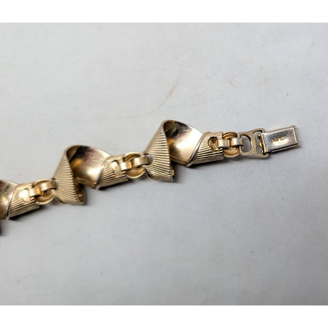 1950s goldtone ridged curled "ribbon" links with goldtone ball connectors bracelet with fold over clasp. Marked "NAPIER"...