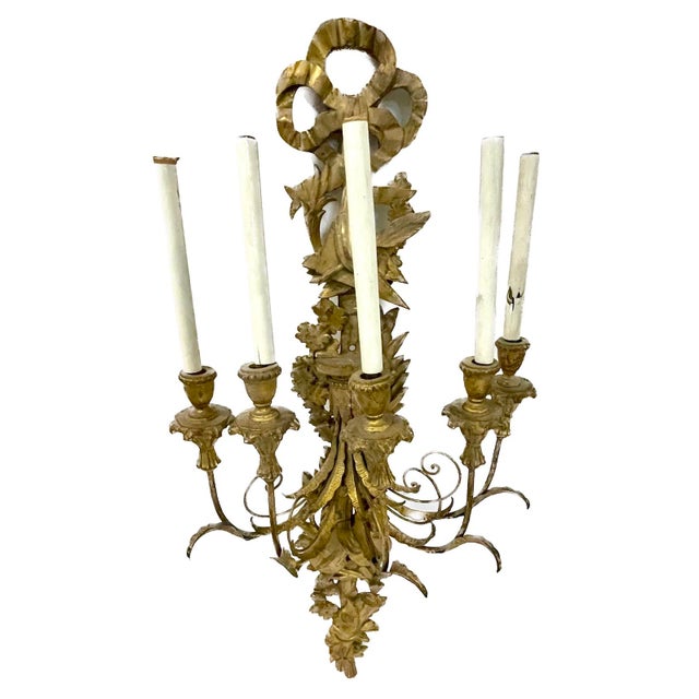 Antique gilt and brass ribbon and musical wall sconce with five arms. Carved gilt ribbon and music themed backplate with...
