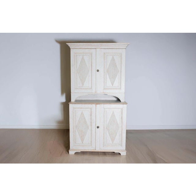 This 18th-century Swedish Gustavian two-part cabinet, circa 1790, is a stunning example of the elegant simplicity that...
