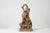 A Rocaille-style terracotta sculpture depicting two children, one arranging a basket of flowers and the other holding a...