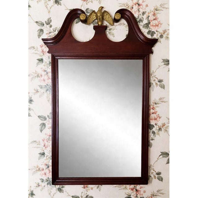 Early 20th century American mahogany mirror in the Federal Revival taste, featuring a scrolled broken pediment centered by...