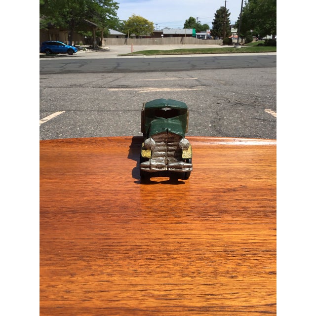 A charming vintage cast iron toy dump truck, beautifully modeled with early 20th-century industrial character and hand-...