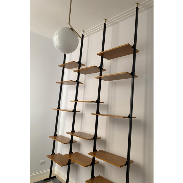 Bookcase in light teak, iron rods and brass finishes, completely restored, the height is adjustable. It has 14 shelves.