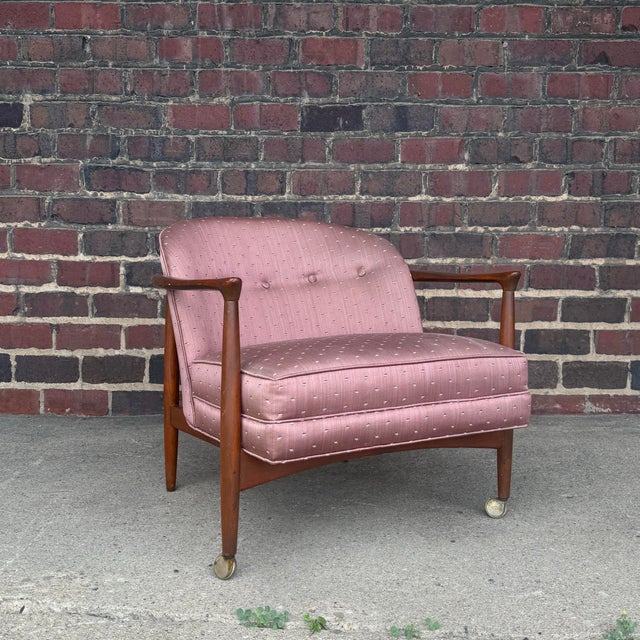 This Finn Andersen for Selig Barrel-Back Lounge Chair features a sculpted wood frame and sateen mauve upholstery.