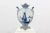 White glazed ceramic vase with Delft blue painted decoration. Flat globular body with two handles in the mouth and four...