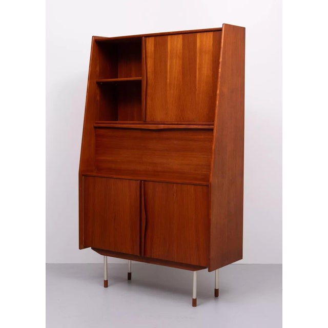 Beautiful teak secretary desk from the 1960s. This charming piece features organically shaped solid teak handles and...