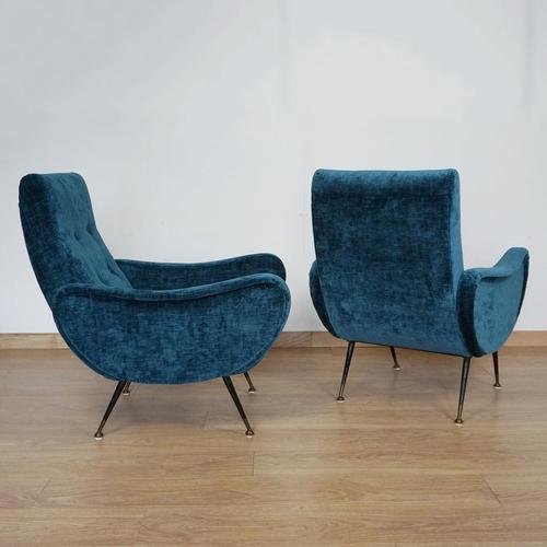 A pair of mid-century armchairs attributed to marco zanuso's 'lady chair'. Re-upholstered in blue fabric with original...