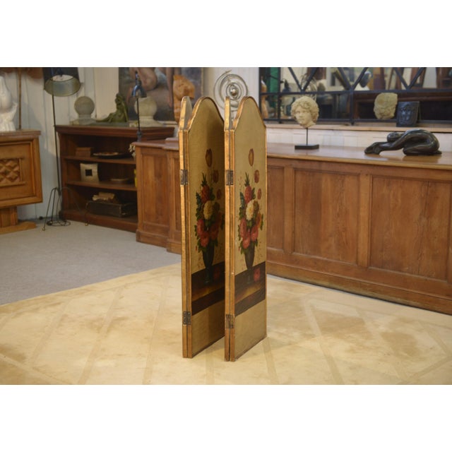An elegant antique four-panel screen, made of gilded wood, each panel adorned with an oil painting depicting generous...