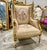 A French Rococo chair with a striking golden frame featuring intricate gold leaf detailing, giving it a luxurious and...