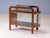 Elegant vintage display cabinet featuring a distinctive curved wooden frame, rounded side section, glass doors, and dark...
