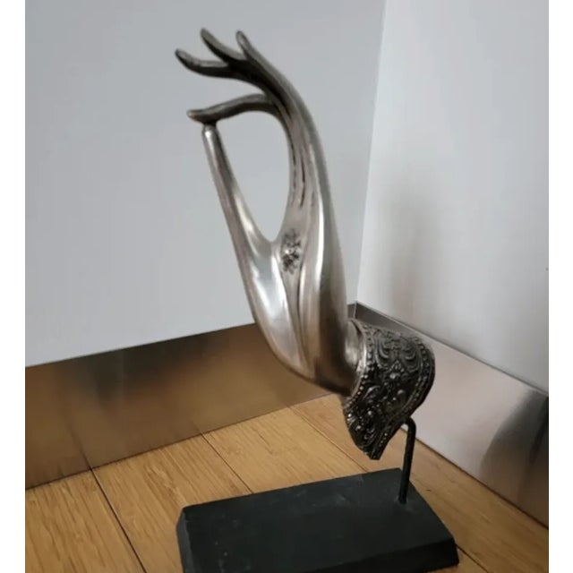 Buddhist hand in metal mounted on a black wooden stand. Vintage Thai sculpture cast metal of Buddha right hand sculpture...