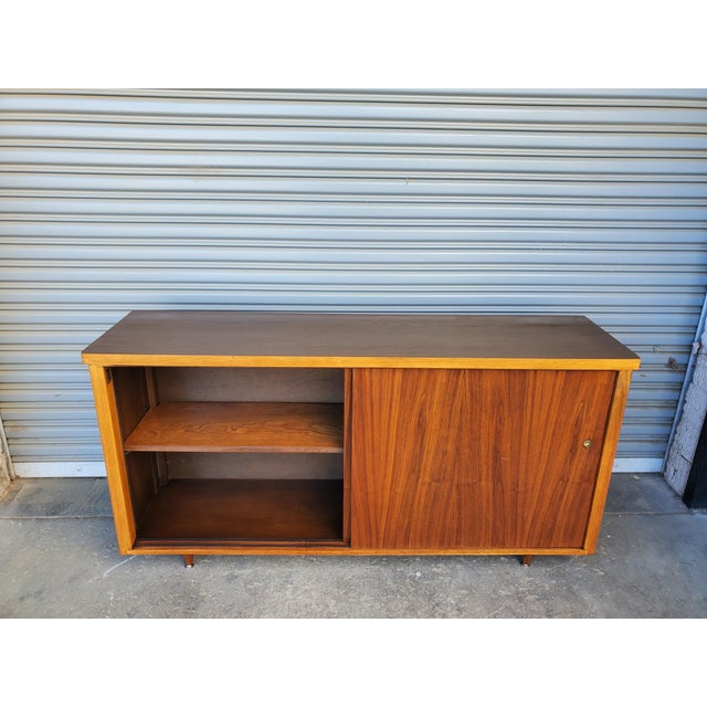 Great looking vintage mid-century credenza. Two large walnut doors that slide to reveal two compartment with two...