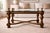 Architectural Neoclassical-style coffee table featuring a sculptural solid wood base, substantial ½-inch beveled glass...