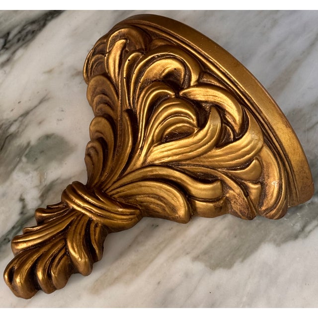 Here is a small wall sconce shelf in classical motif, gold gilt aged finish in traditional Italian style. Ideal in size to...