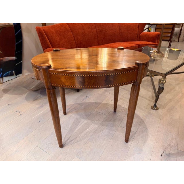 A French empire style occasional oval table in satinwood with inlay detailing . C1920-1929 .
