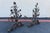 A spectacular pair of 19th-century Italian wrought iron andirons, richly adorned with hand-forged floral motifs and...