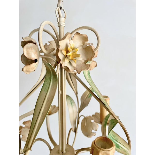 Vintage painted tole chandelier featuring a four-light cage form decorated with hand-shaped flowers, leaves, and botanical...