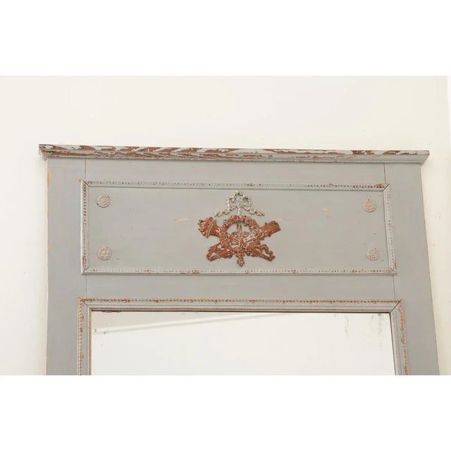 This large 19th century French trumeau mirror is quite elegant, pared down to minimal decorative carvings that suggest a...