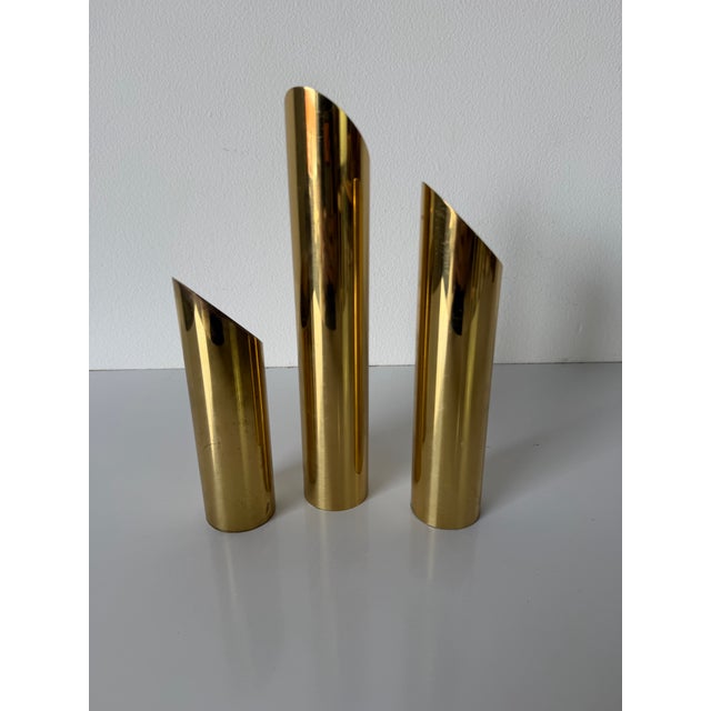 A striking set of three Mid Century Modern brass candle holders, crafted in Denmark. Featuring sleek cylindrical forms...