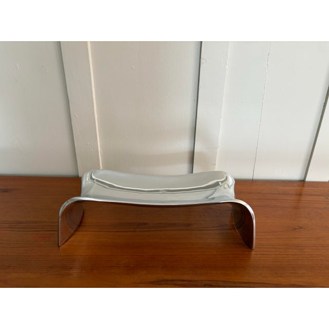 Sculptural silver-tone bench tray designed by Neil Cohen for Nambe, dated 2007 per maker’s mark. This contemporary design...
