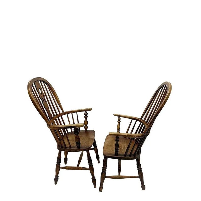 A set of oak Windsor chairs with a high, rounded back with bars. The chairs with round curved armrests on 4 twisted oak...