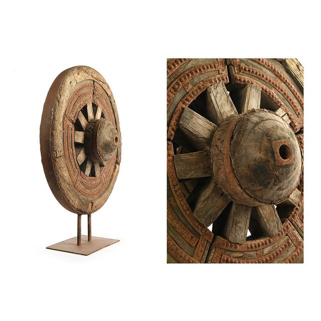 Wooden wheel on metal stand. Wooden decorative object placed on a metal foot. This piece is designed in the style of the...