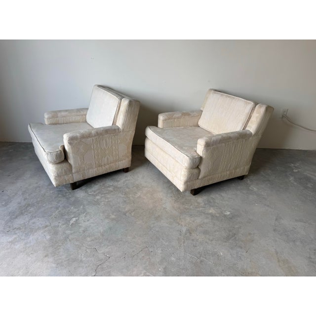 A handsome pair of 1970’s Mid-Century Modern lounge chairs in the style of Dunbar. These generous club chairs feature...