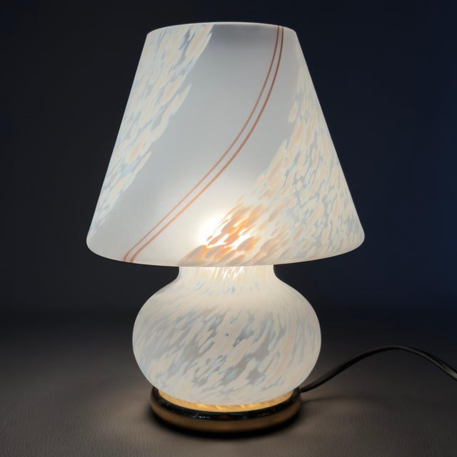 Refined and luminous mushroom-shaped table lamp in fine Murano blown glass with a brass base, complete with an authentic...