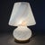 Refined and luminous mushroom-shaped table lamp in fine Murano blown glass with a brass base, complete with an authentic...