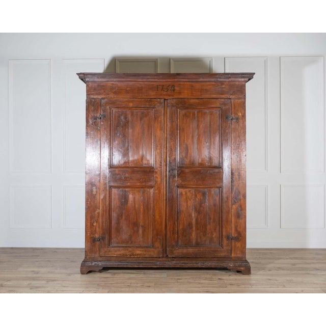 A stately 18th-century Italian wardrobe, handcrafted in solid poplar and dated 1751, as inscribed across the upper frieze....