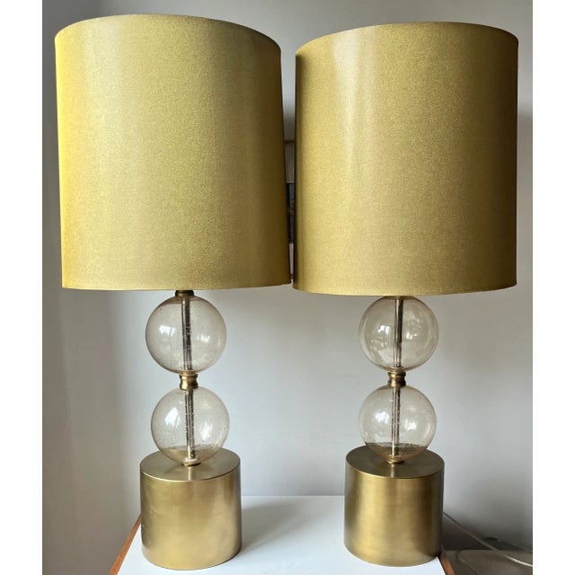 This fabulous pair of large Arteriors Home Gold lamps feature Gold seeded hand-blown glass globes, metal bases and raw...