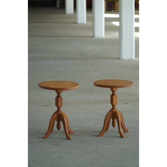 A beautiful pair of Danish modern pedestal side tables crafted in oak, circa 1960s. Each table features a round top...