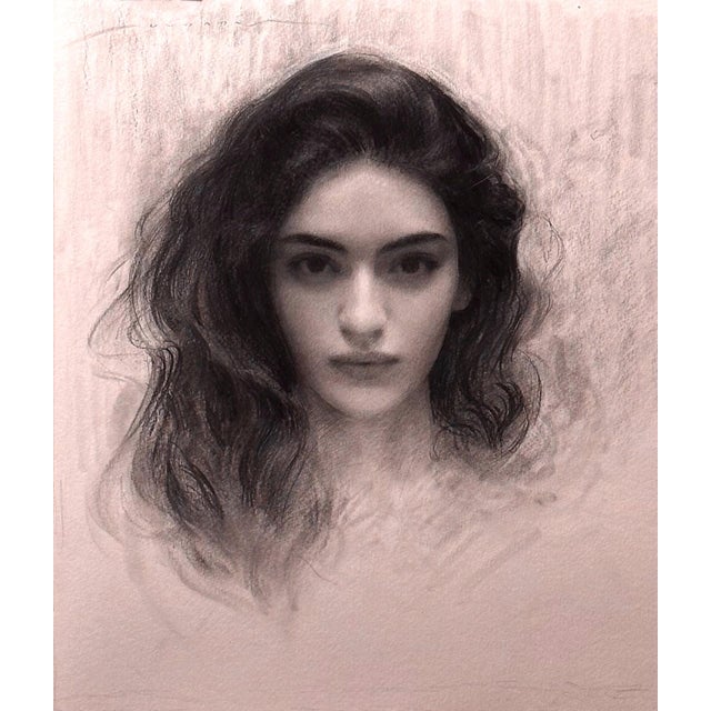 This charcoal portrait captures the serene expression of a young girl, her wavy hair softly framing her face. The delicate...