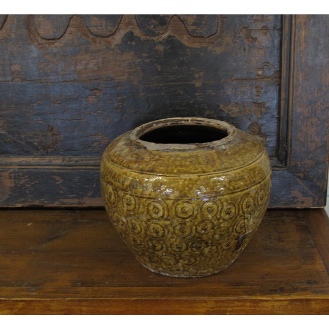 The body of this antique vase is covered with small hand carved circular coins and glazed with aged mustard color. Nice...