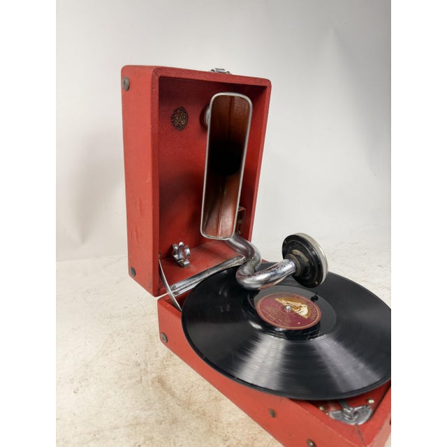 Charming red suitcase gramophone with chrome trim, complete with tonearm and original headshell. An ideal collector's item...