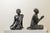 A pair of freestanding sculptures depicting two Buddhist monks in an attitude of devotion and respect, wearing traditional...