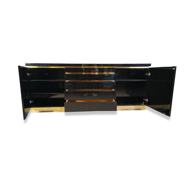 Luxurious seventies glamour sideboard by Jean Claude Mahey consisting of black lacquer panels and brass. The use of...