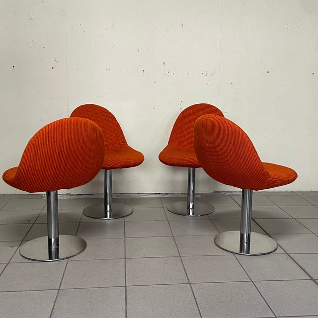 Set of four chairs dating back to the 1970s, fully restored. These chairs feature a solid chrome-plated metal swivel...
