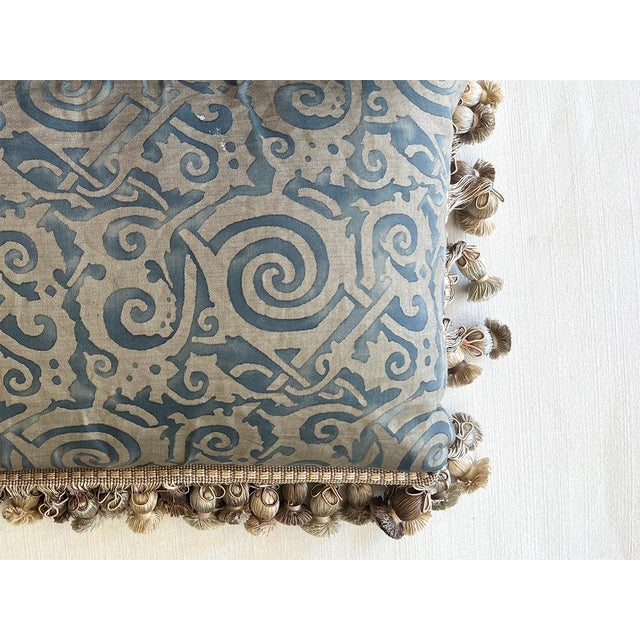 This pillow is made of vintage Fortuny fabric. It is lined with fringe and tassels.