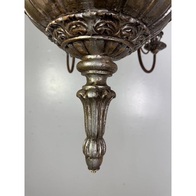A beautifully aged Italian chandelier featuring a carved silvered wood central column with fluted and gadrooned details....