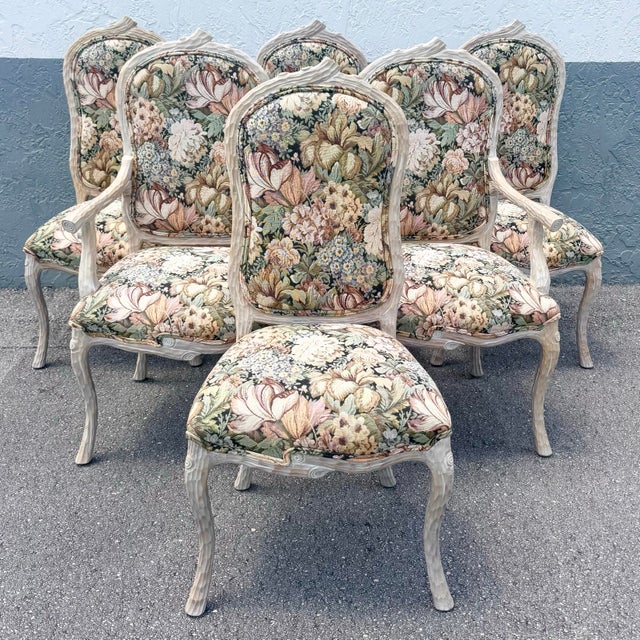 Elegant French Provincial dining chairs showcasing a beautifully sculpted faux bois frame, designed to mimic the organic...