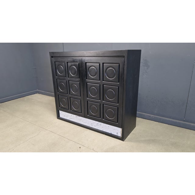 Black ebonized wood bar cabinet with graphical brutalist design doors and a marble inlay at the base INtegrated drawers...