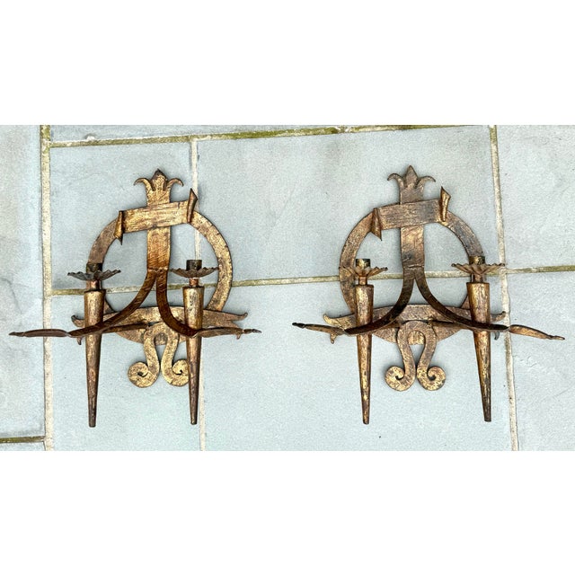A substantial pair of early 20th-century hand-forged wrought iron wall sconces featuring bold Spanish Revival design with...